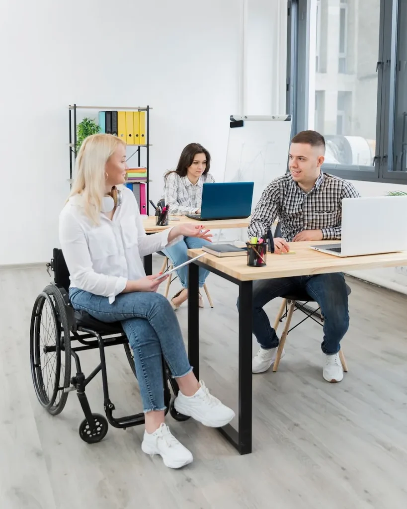 Woman in wheelchair discussing care with support staff